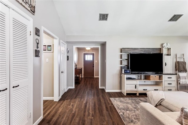 living room featuring vaulted ceiling, visible vents, dark wood finished floors, and baseboards