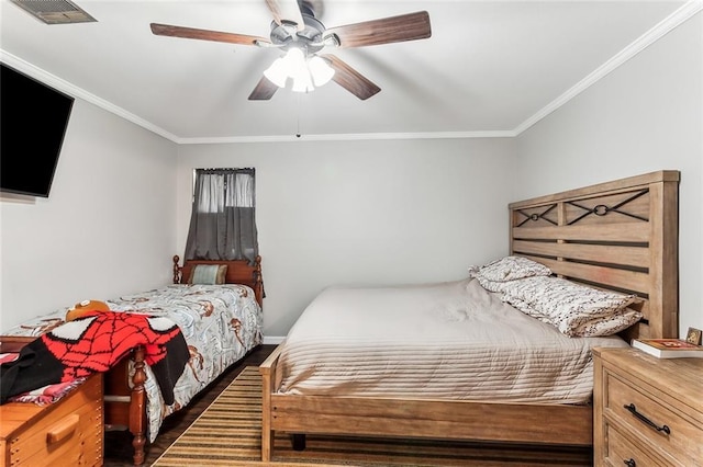 bedroom featuring a ceiling fan, wood finished floors, visible vents, and crown molding