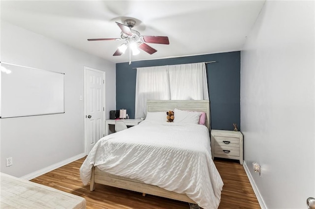 bedroom featuring a ceiling fan, baseboards, and wood finished floors