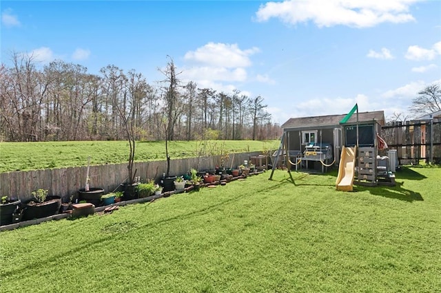 view of yard featuring a fenced backyard and a playground