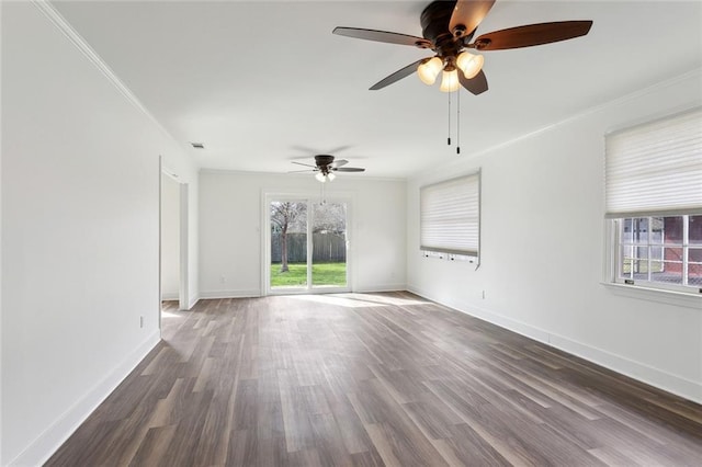 unfurnished room with ornamental molding, plenty of natural light, baseboards, and wood finished floors