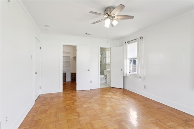 unfurnished bedroom with baseboards, a spacious closet, connected bathroom, and crown molding