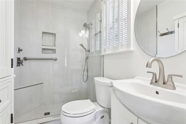 full bathroom with a tile shower, vanity, and toilet