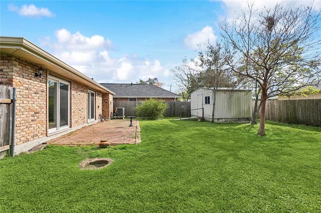 view of yard featuring a patio area, a fenced backyard, an outdoor structure, and a shed