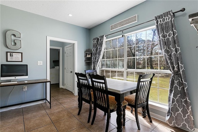 dining space with tile patterned flooring, washer / clothes dryer, and baseboards