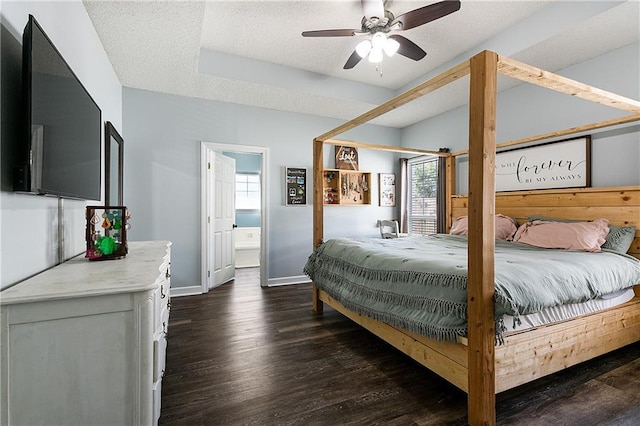 bedroom featuring a textured ceiling, connected bathroom, dark wood-type flooring, a ceiling fan, and baseboards