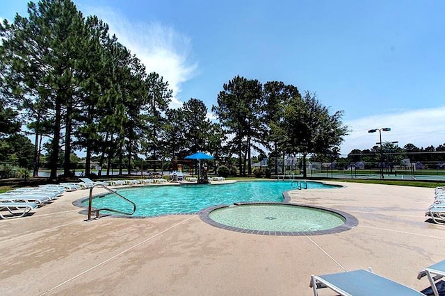 pool with a patio area and fence