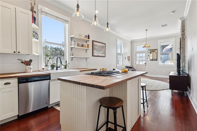 kitchen with crown molding, open shelves, stainless steel appliances, butcher block counters, and a sink