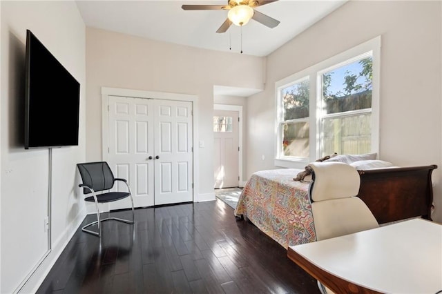 bedroom featuring a closet, dark wood finished floors, baseboards, and ceiling fan