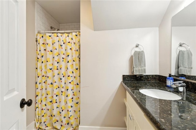 full bath with curtained shower, baseboards, and vanity