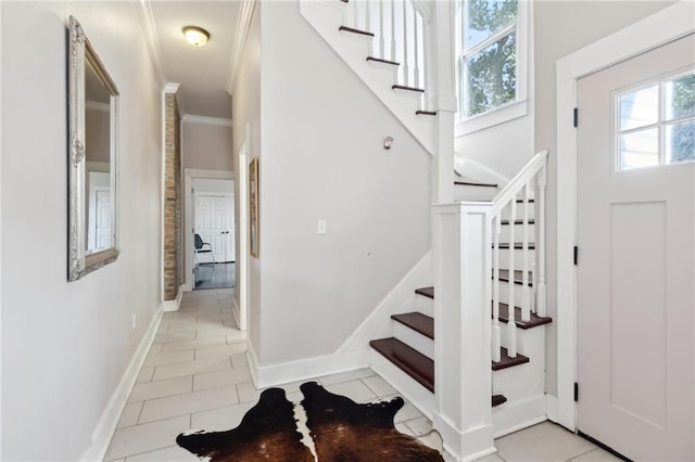 entryway featuring ornamental molding, light tile patterned flooring, a wealth of natural light, and baseboards