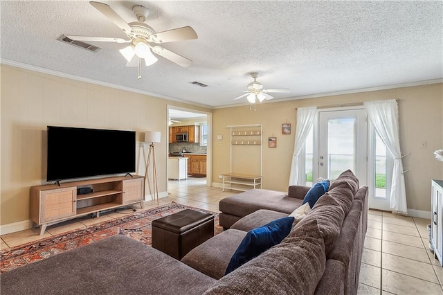 living area with a textured ceiling, visible vents, crown molding, and light tile patterned flooring