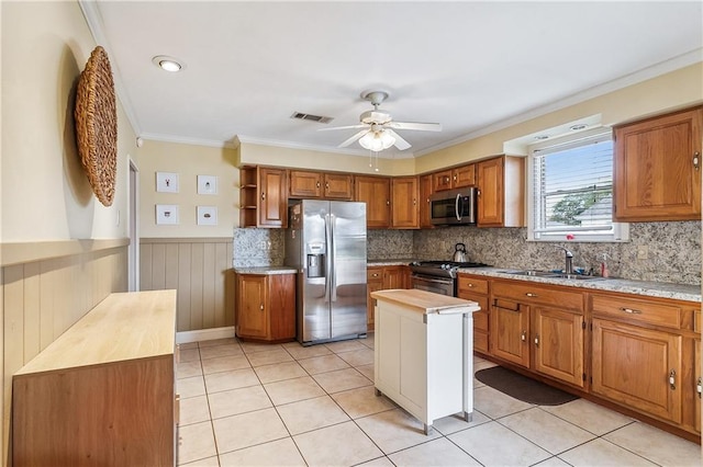 kitchen with stainless steel appliances, light countertops, visible vents, brown cabinetry, and a sink