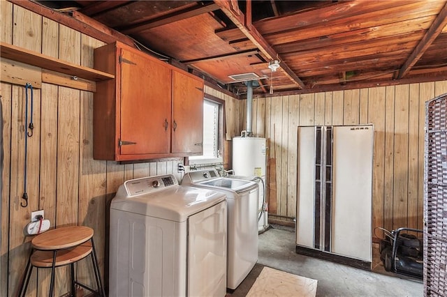 laundry room with wooden walls, water heater, separate washer and dryer, and cabinet space