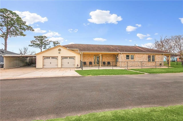 ranch-style home featuring a garage, concrete driveway, fence, a front lawn, and brick siding