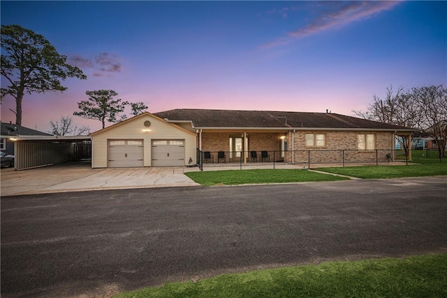 ranch-style home featuring brick siding, a lawn, fence, a garage, and driveway