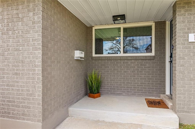 view of exterior entry with brick siding