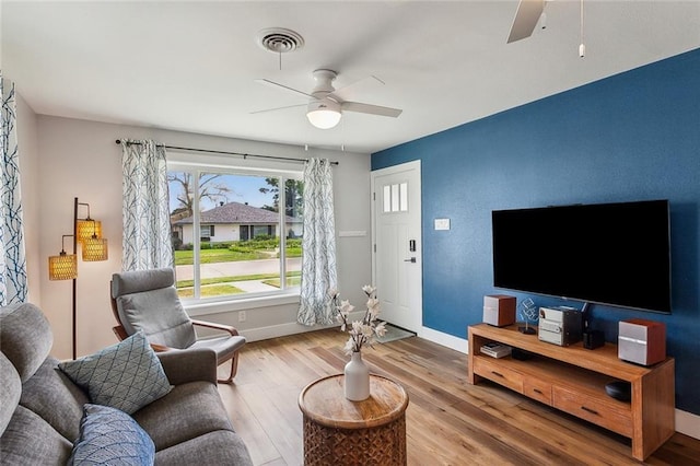 living area with baseboards, ceiling fan, visible vents, and wood finished floors