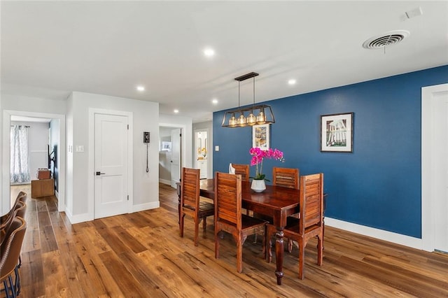 dining room with baseboards, visible vents, wood finished floors, and recessed lighting