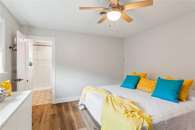 bedroom with wood finished floors, a ceiling fan, and baseboards