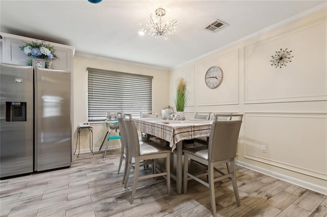 dining area with an inviting chandelier, visible vents, a decorative wall, and ornamental molding