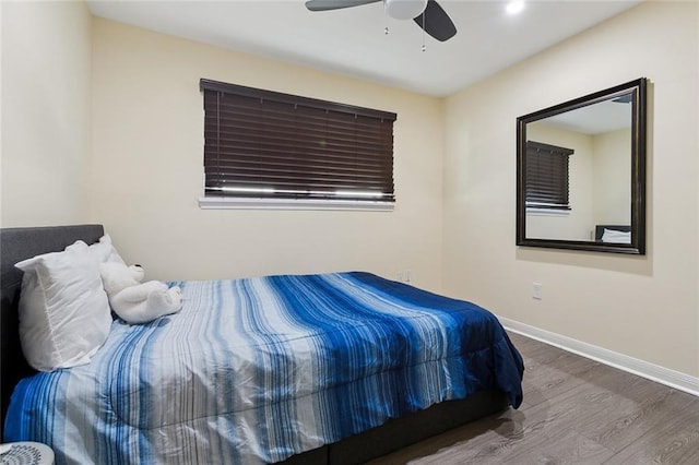 bedroom featuring a ceiling fan, baseboards, and wood finished floors