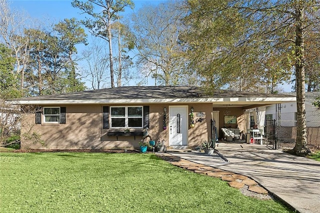 ranch-style home featuring a front yard, brick siding, fence, and driveway