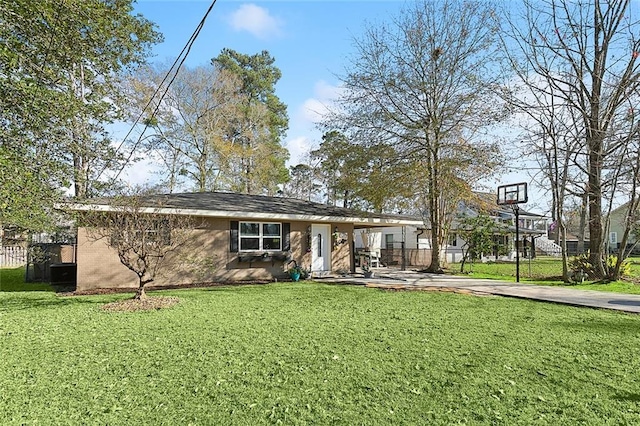 view of front facade with brick siding, fence, and a front yard