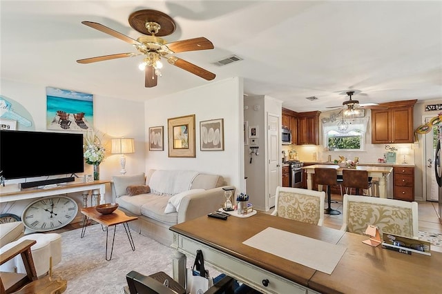 living area featuring visible vents and a ceiling fan