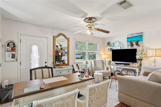 living area featuring visible vents and ceiling fan