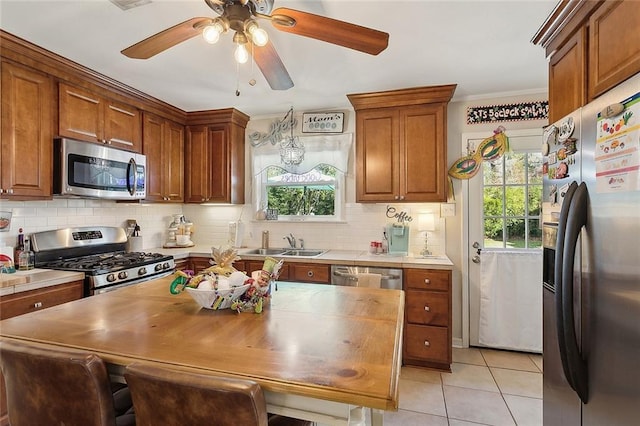 kitchen featuring a wealth of natural light, appliances with stainless steel finishes, backsplash, and a sink