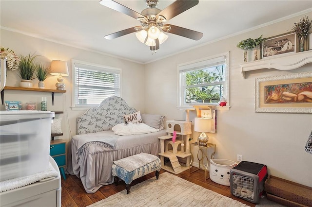 bedroom with ceiling fan, ornamental molding, wood finished floors, and baseboards