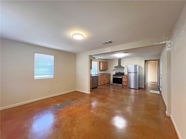 kitchen with plenty of natural light, visible vents, wall chimney exhaust hood, appliances with stainless steel finishes, and finished concrete floors