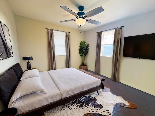 carpeted bedroom with a ceiling fan and baseboards