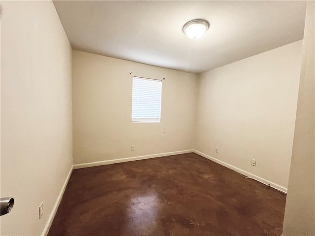 empty room with baseboards and concrete flooring