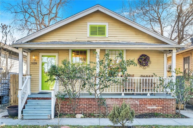 bungalow-style house with a shingled roof and a porch