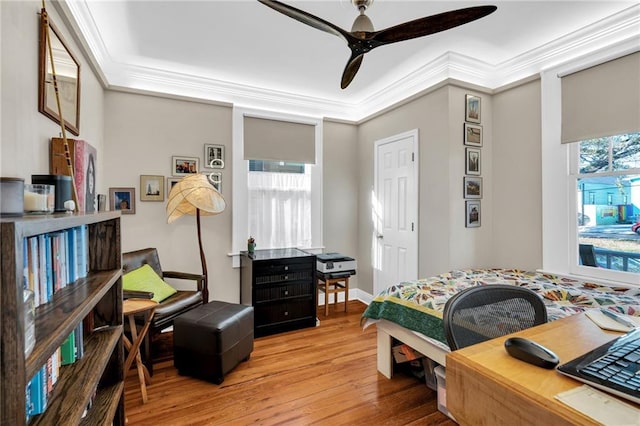 bedroom with a ceiling fan, crown molding, and hardwood / wood-style floors