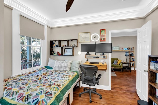 bedroom featuring ornamental molding, ceiling fan, baseboards, and wood finished floors