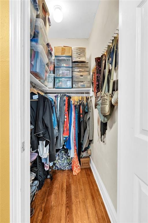 walk in closet with wood finished floors