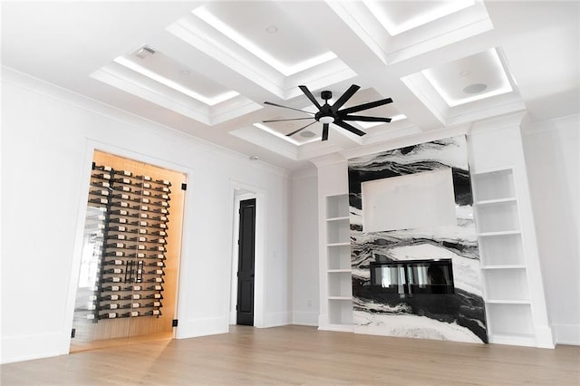 interior space featuring beam ceiling, visible vents, ornamental molding, wood finished floors, and coffered ceiling