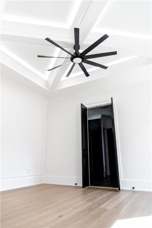 empty room with a ceiling fan, light wood-style flooring, and baseboards