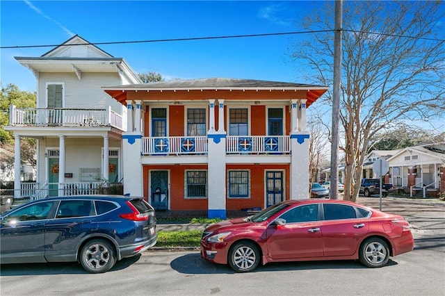 view of front facade featuring a balcony and brick siding