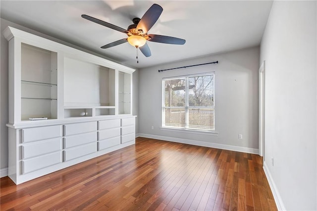 unfurnished bedroom featuring wood-type flooring, baseboards, and a ceiling fan