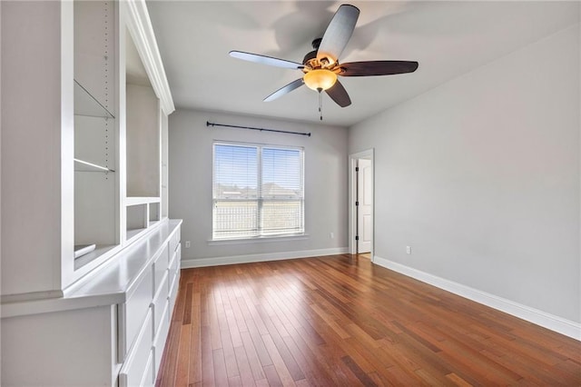 spare room featuring a ceiling fan, baseboards, and hardwood / wood-style floors