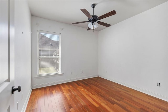 unfurnished room featuring hardwood / wood-style flooring, ceiling fan, and baseboards