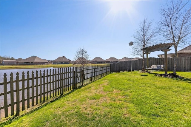 view of yard with a water view, a fenced backyard, and a residential view