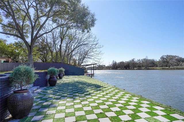 view of property's community featuring a water view and fence