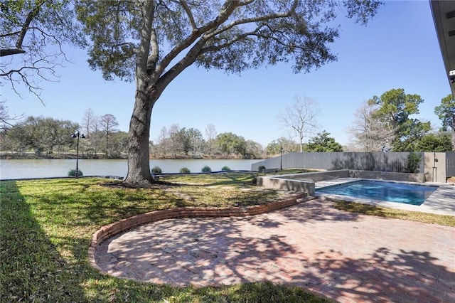 view of swimming pool featuring a fenced in pool, a patio, a water view, fence, and a yard