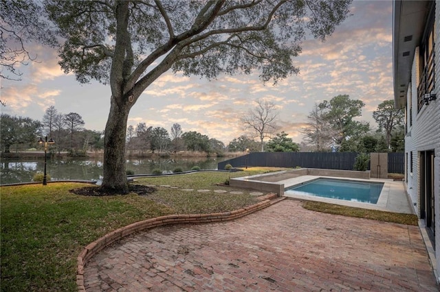 view of swimming pool featuring a patio, a fenced backyard, a water view, a yard, and a fenced in pool