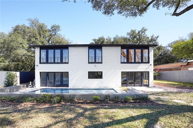 back of house with a patio area, fence, a fenced in pool, and brick siding